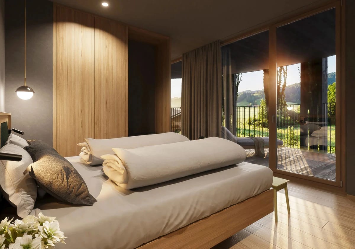 Helles Doppelzimmer mit Holzbett, Sitzecke und Balkon mit Landschaftsblick